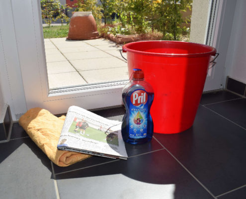 Fenster putzen mit Zeitung, Spüli, Eimer und Lappen